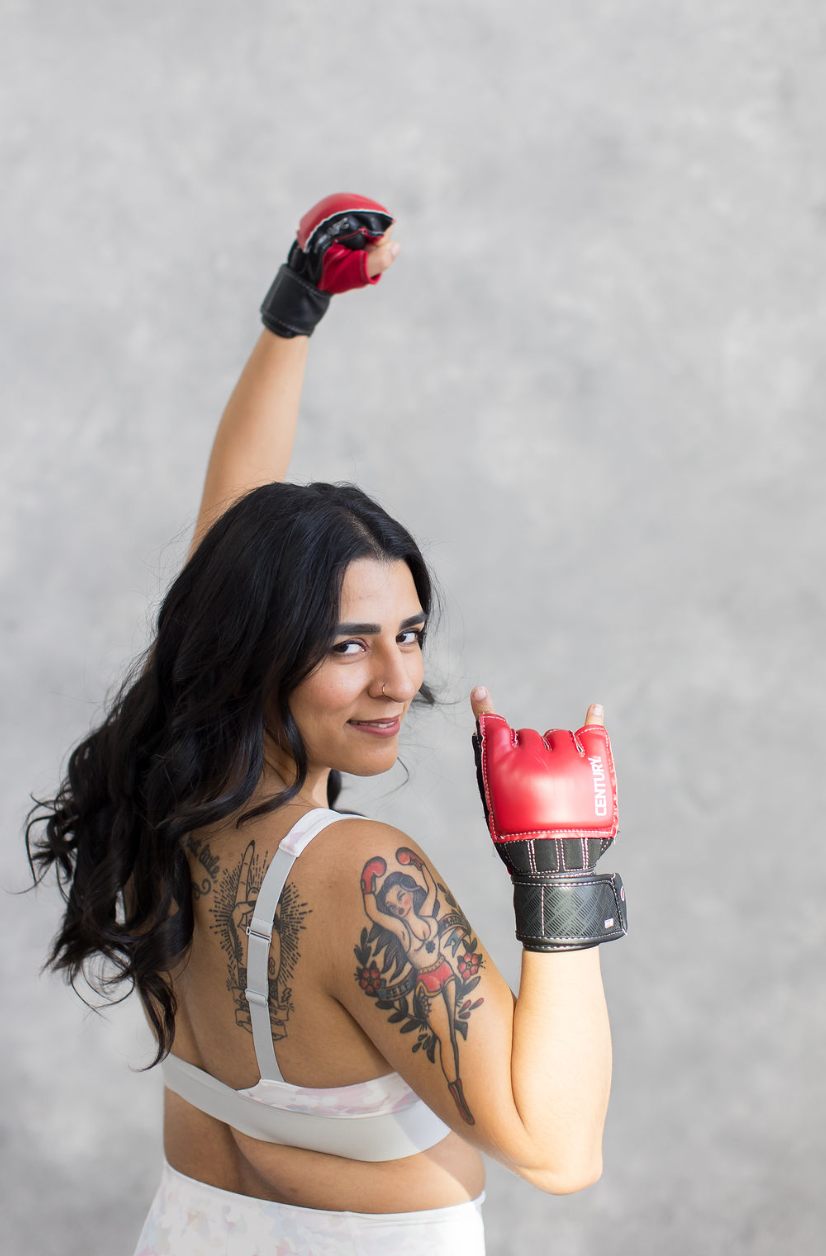 Sydney Meza wearing red training gloves, raising one fist overhead